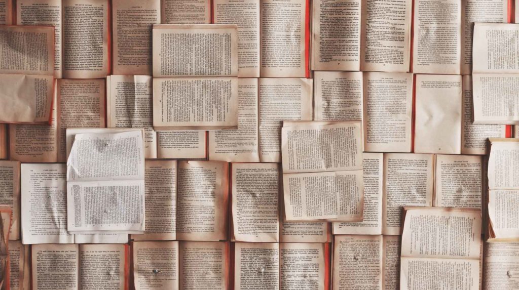 view from above of a table full of open books laying next to each other